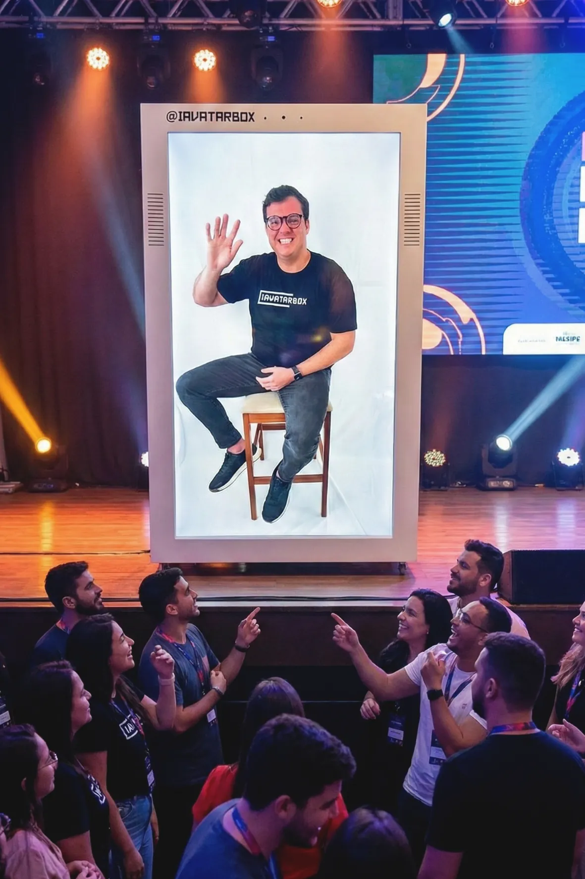 Avatar em IA projetado em telão diante do público do evento